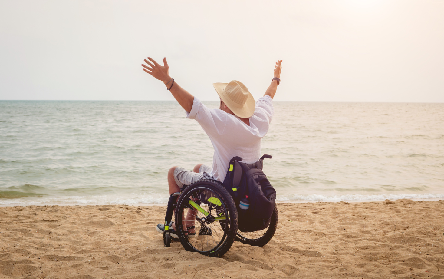 Disabled man in a wheelchair on the beach.